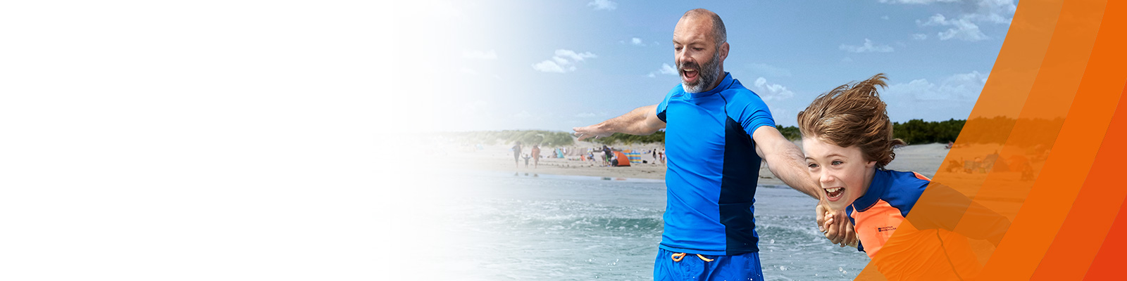 Father and son rushing into the sea cheerfully on a sunny day