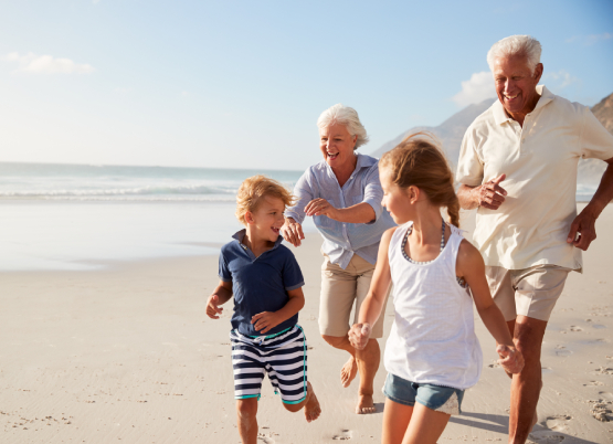 Grandparents playing with grandchildren on the beach