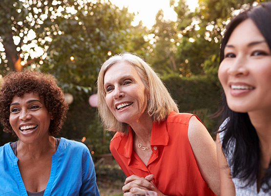 three women smiling outside 