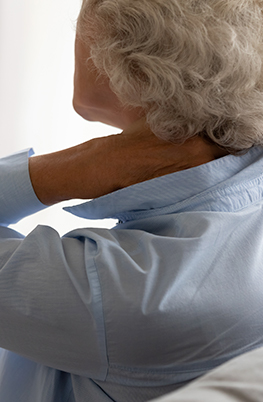 Older woman holding her neck in discomfort