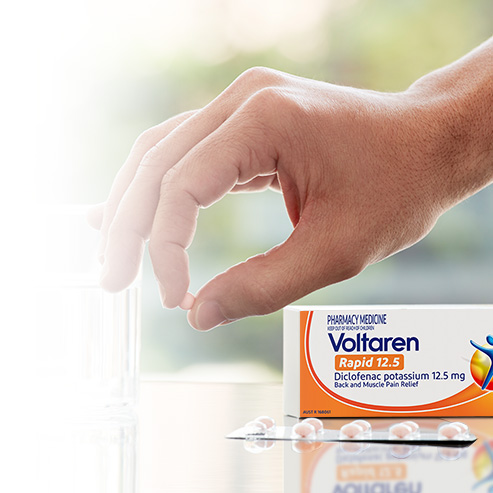 Voltaren Rapid 12.5 packshot with hand holding tablet