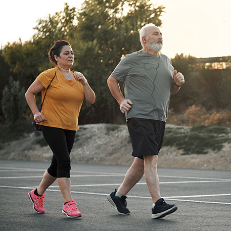 woman and man jogging in street