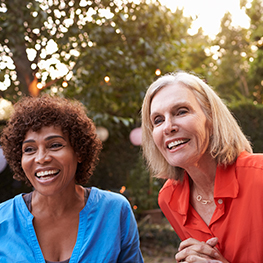 three women smiling outside